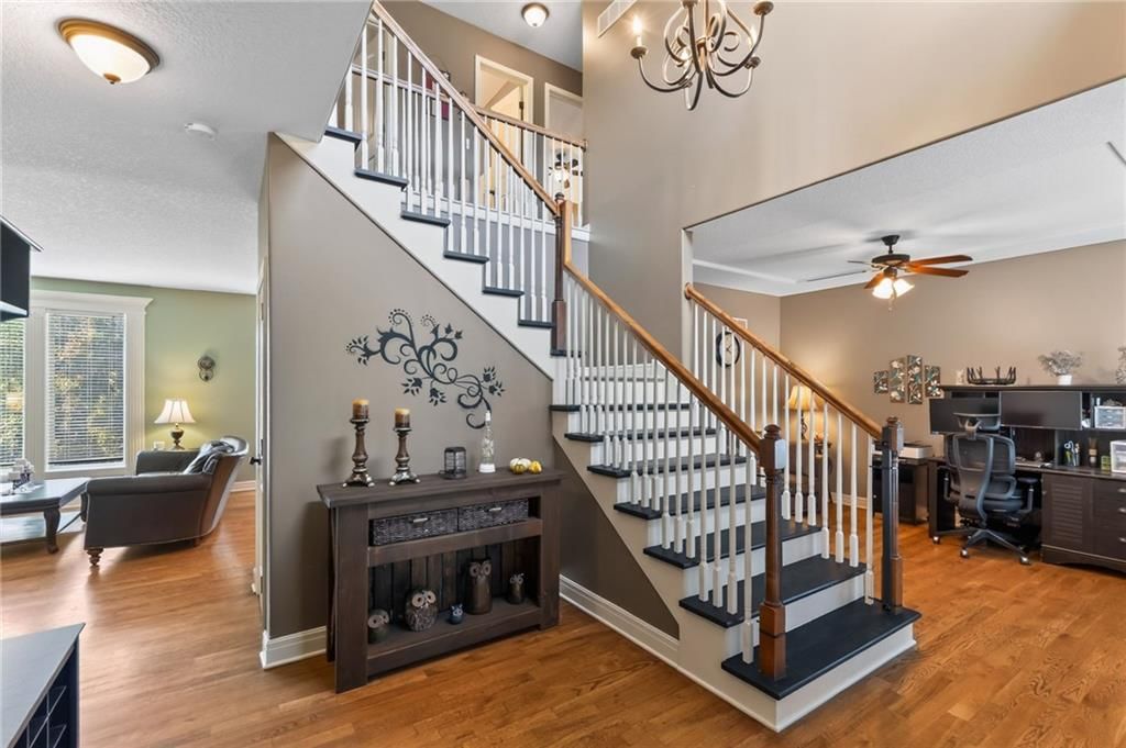 Hardwood floors, statement lighting and staircase at 406 Buck Court, Kearney, MO 64060