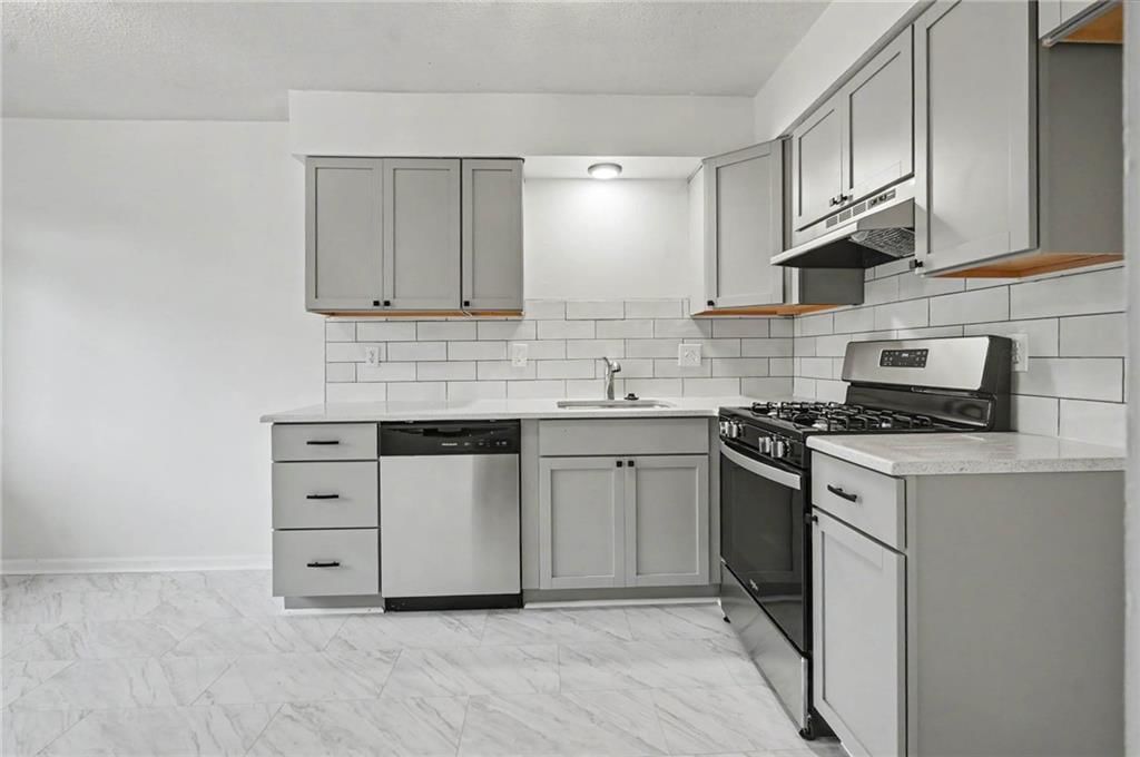 Gas range, gray kitchen cabinets and shaker cabinets at 9734 Hadley Drive, Overland Park, KS 66212