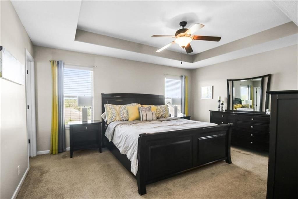 Main-floor primary bedroom and tray ceiling at 1252 NW High View Drive, Grain Valley, MO 64029