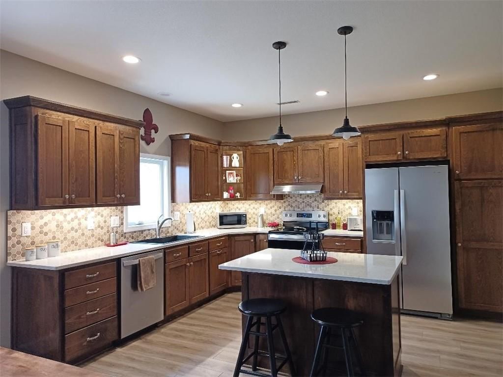 Kitchen island, shaker cabinets and stainless steel appliances at 916 Cedar Court, Paola, KS 66071