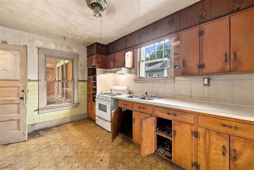 Gas range, wood kitchen cabinets and white appliances at 925 Pottawatomie Street, Leavenworth, KS 66048