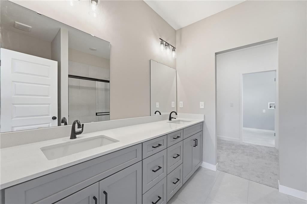 Tile floors, double vanity and gray vanity at 1600 SW 10th Terrace, Oak Grove, MO 64075