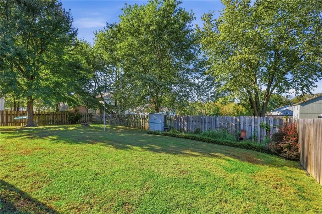 Fenced yard, mature trees and flat lot at 10504-06 Maple Avenue, Peculiar, MO 64078