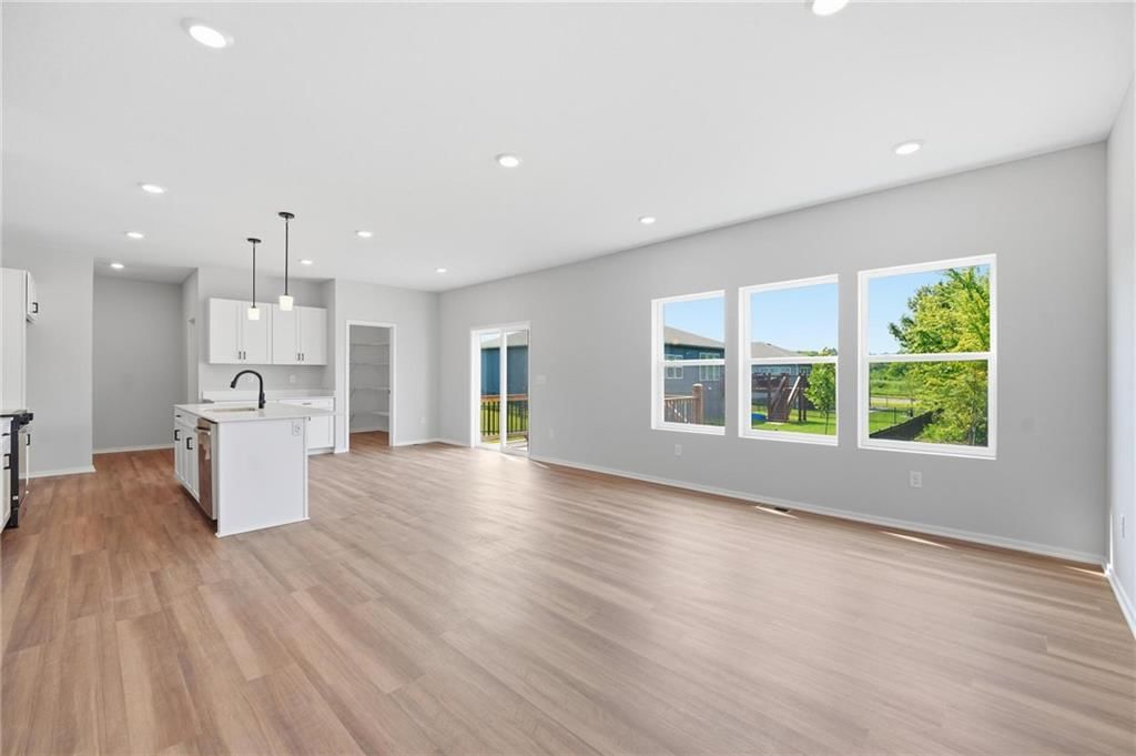 Open floor plan, kitchen island and white kitchen at 1601 SW 10th Terrace, Oak Grove, MO 64075