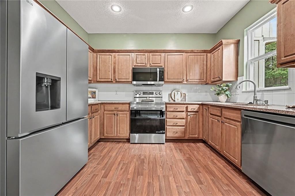 Wood kitchen cabinets, electric range and kitchen backsplash at 7313 McCoy Street, Shawnee, KS 66227