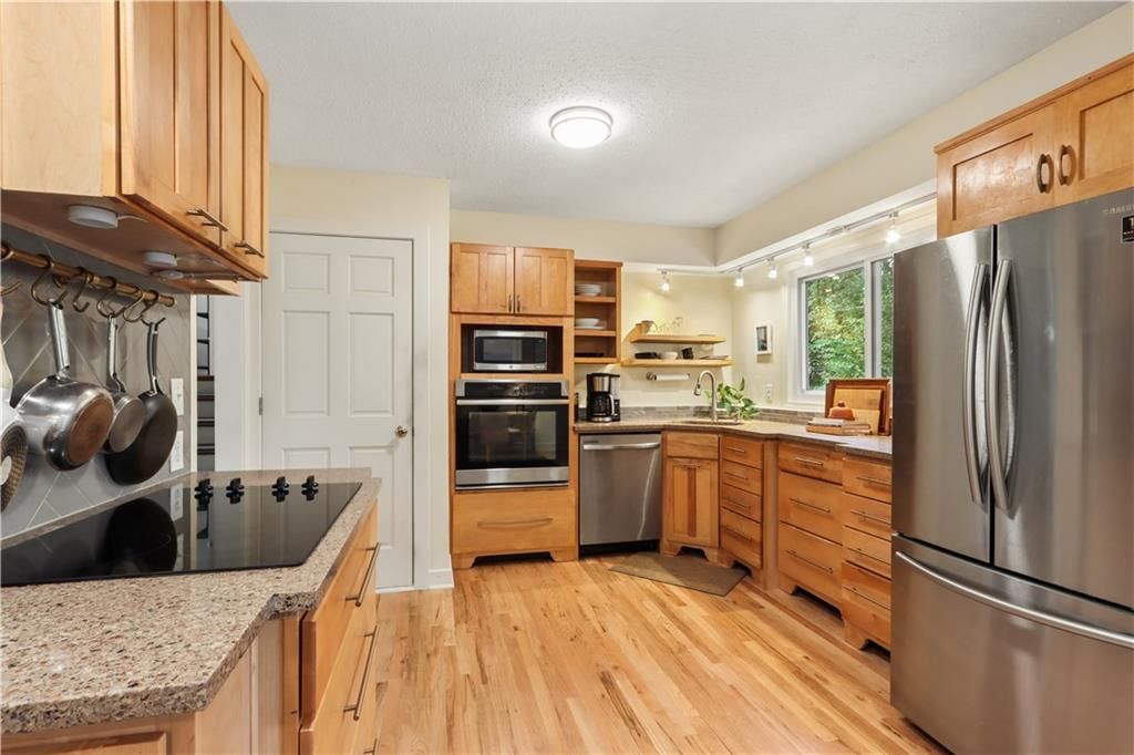 Stainless steel appliances, wood kitchen cabinets and electric range at 4107 E 107th Terrace, Kansas City, MO 64137