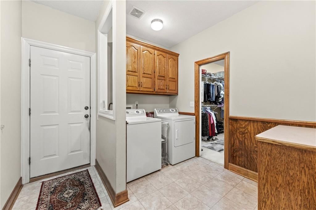 Main-floor primary bedroom and tile floors at 29483 Masters Court, Louisburg, KS 66053
