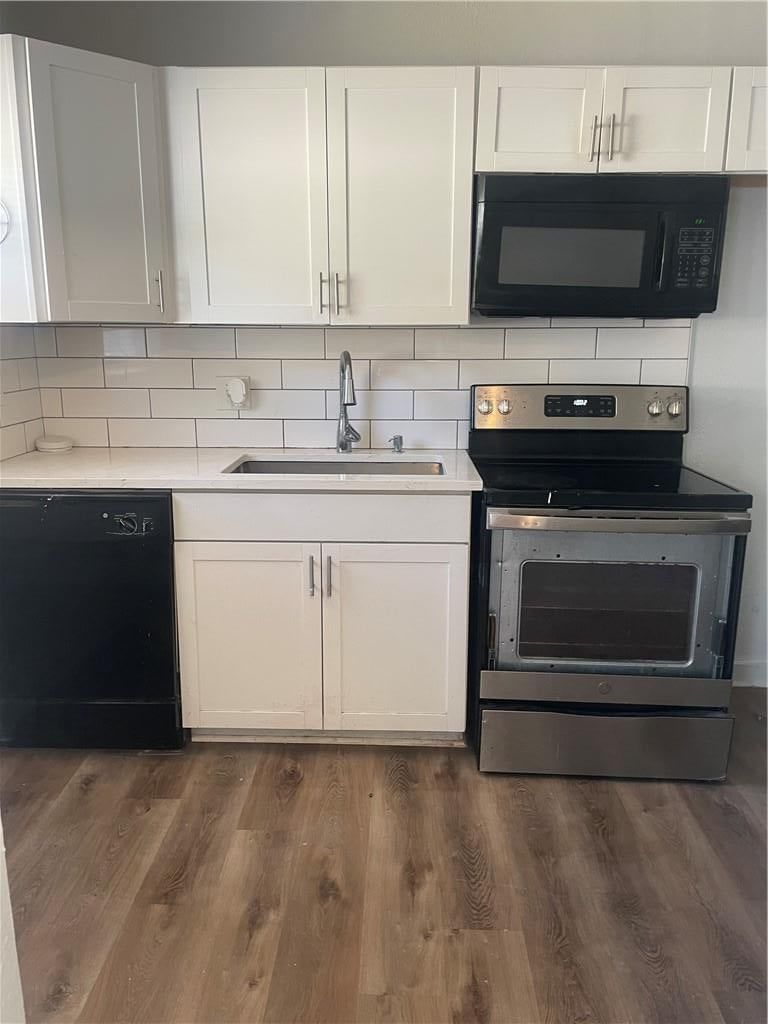 White kitchen, shaker cabinets and electric range at 2107 E 77th Terrace, Kansas City, MO 64132