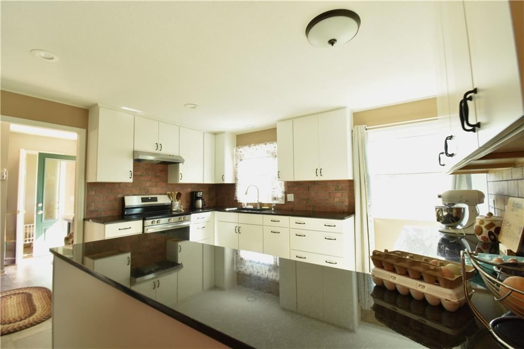 Kitchen island, white kitchen and exposed brick wall at 9700 W 319th Street, Louisburg, KS 66053