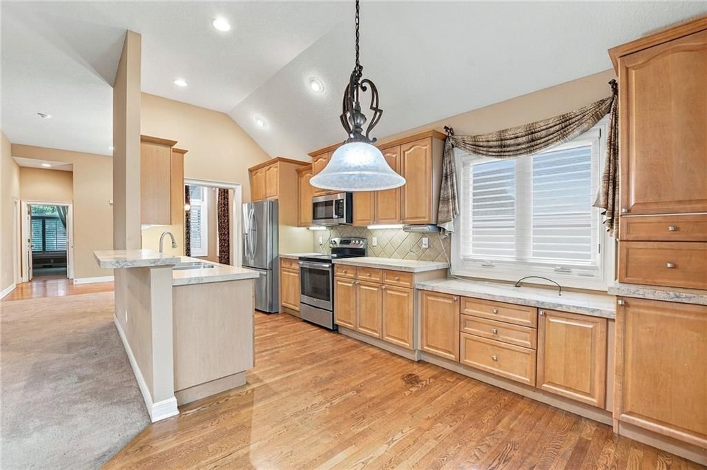Stainless steel appliances, breakfast nook and wood kitchen cabinets at 13408 Summit Court, Kansas City, MO 64145