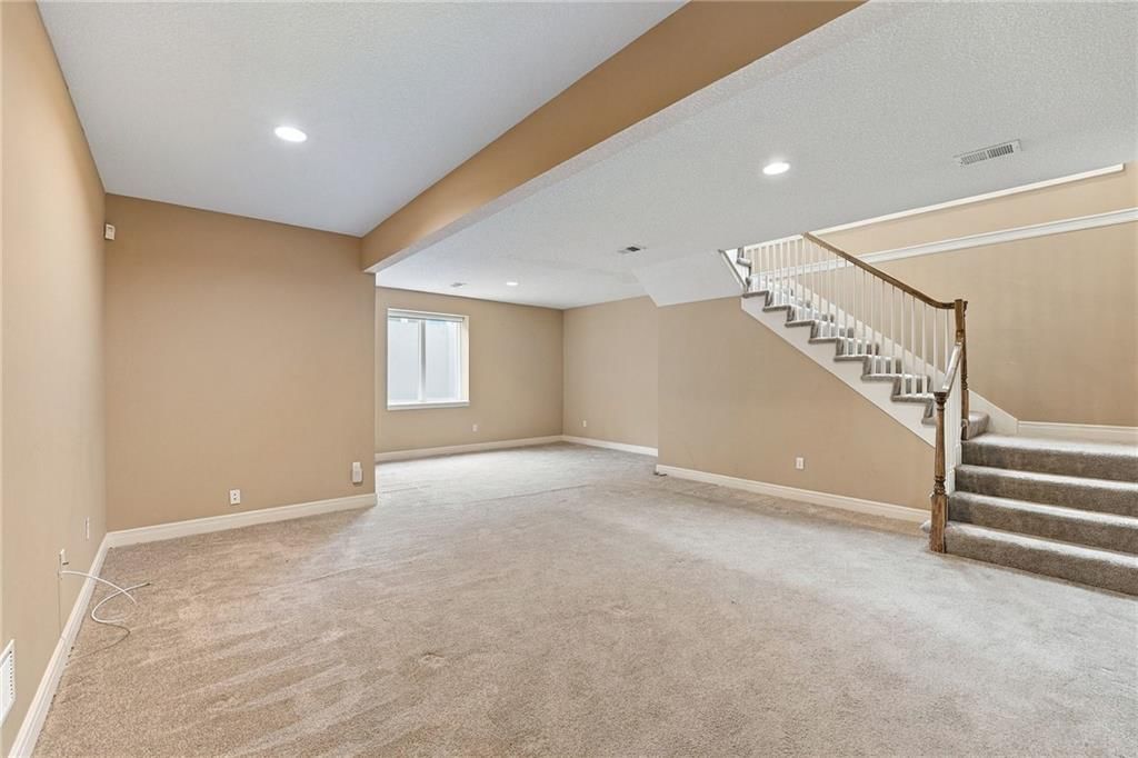Finished basement, staircase and wood stair railing at 13408 Summit Court, Kansas City, MO 64145