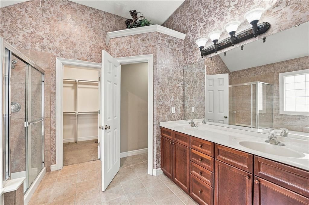 Walk-in shower, tiled shower and double vanity at 13408 Summit Court, Kansas City, MO 64145