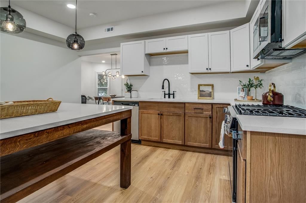 Kitchen island, gas range and two-tone kitchen cabinets at 24050 W 55th Street, Shawnee, KS 66226