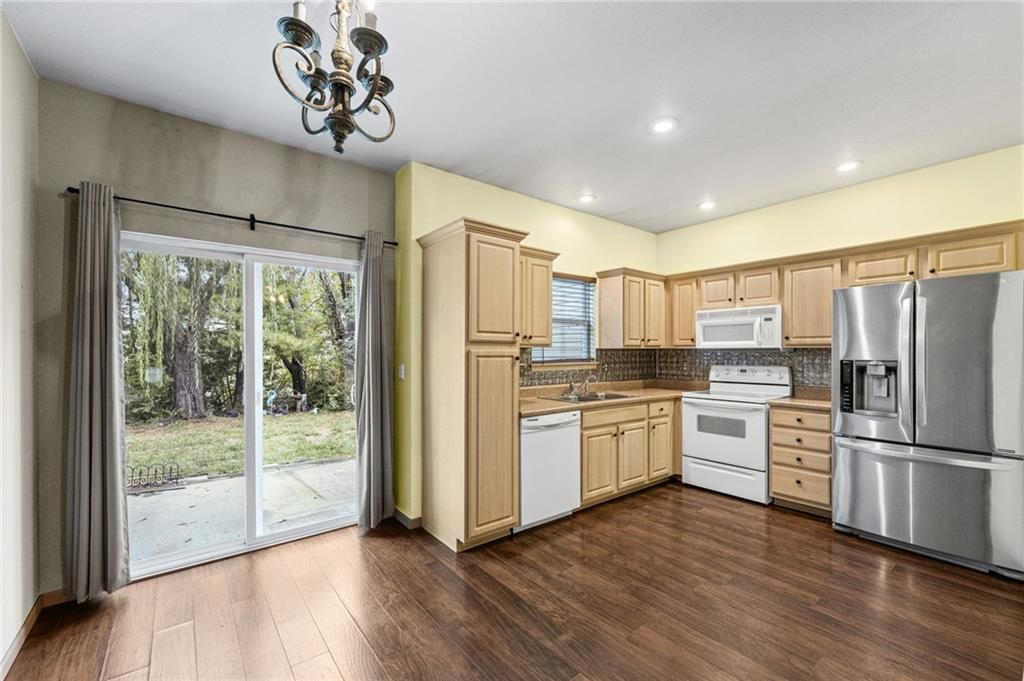 Wood kitchen cabinets, electric range and kitchen backsplash at 1623 SW Mission Road, Lee's Summit, MO 64081