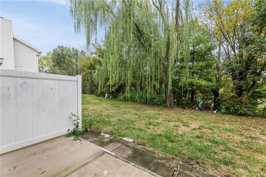Fenced yard, mature trees and vinyl fence at 1623 SW Mission Road, Lee's Summit, MO 64081