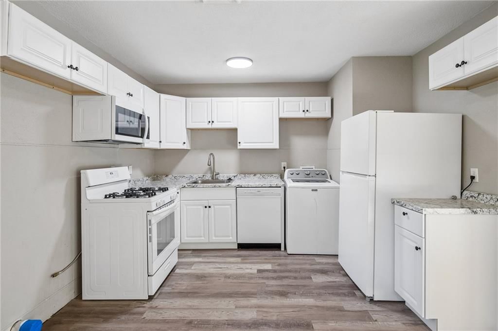 Open floor plan, white kitchen and gas range at 11305 Mckinley Avenue, Kansas City, MO 64134