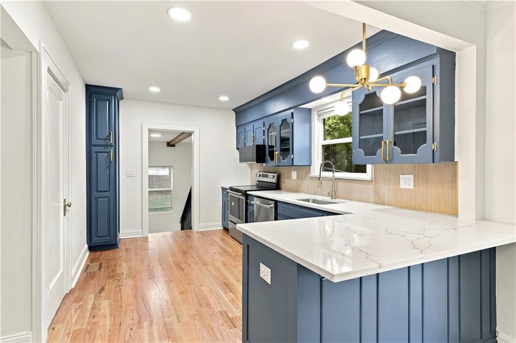 Quartz counters, blue kitchen cabinets and stainless steel appliances at 9358 E 64th Terrace, Raytown, MO 64133