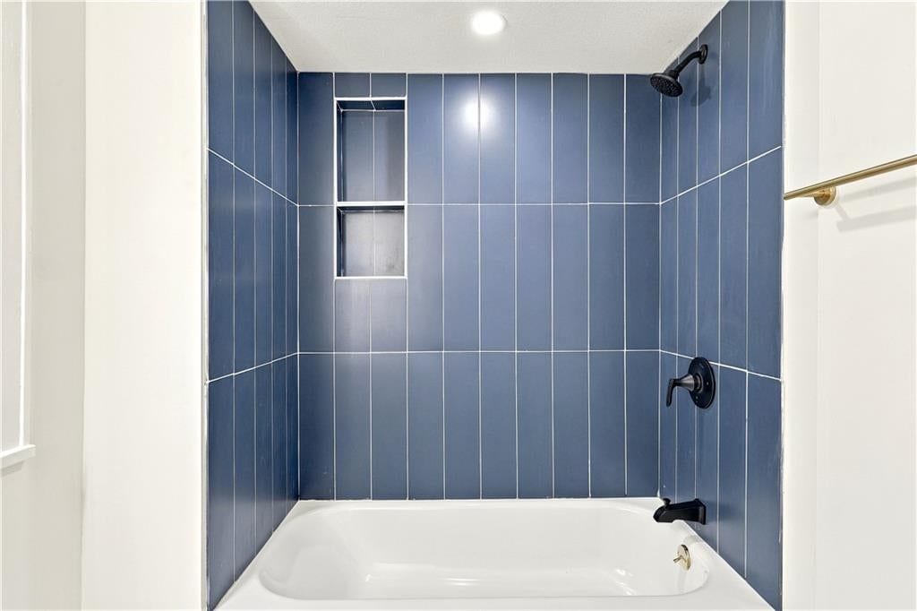 Tiled shower and renovated bathrooms at 9358 E 64th Terrace, Raytown, MO 64133