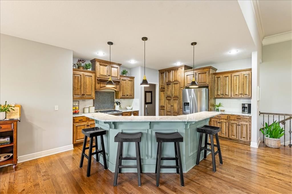 Kitchen island, granite counters and gas range at 15096 NW 66th Street, Parkville, MO 64152