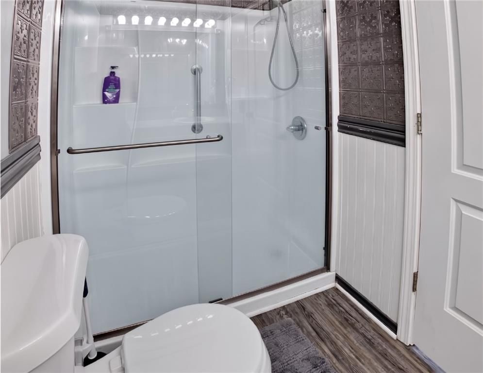Wainscoting or board and batten, shiplap / paneling and frameless glass shower at 1001 Peggy Drive, Greenwood, MO 64034