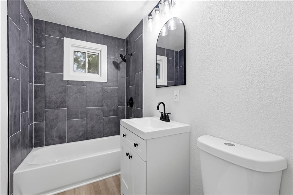 Tiled shower and renovated bathrooms at 702 SW Locust Street, Oak Grove, MO 64075