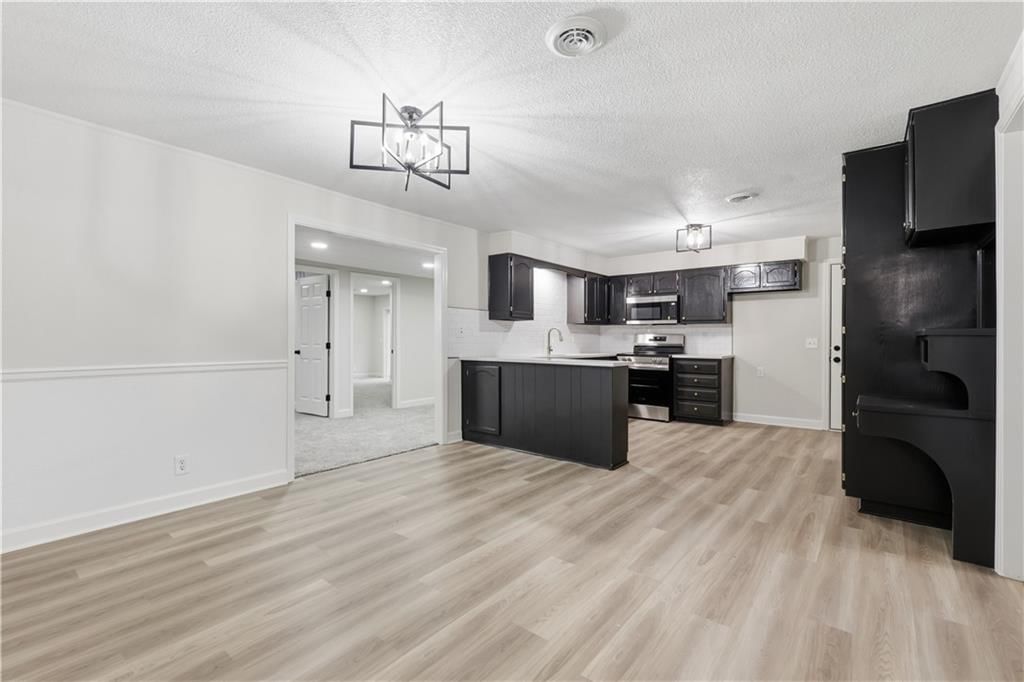 Open floor plan, luxury vinyl floors and breakfast nook at 702 SW Locust Street, Oak Grove, MO 64075
