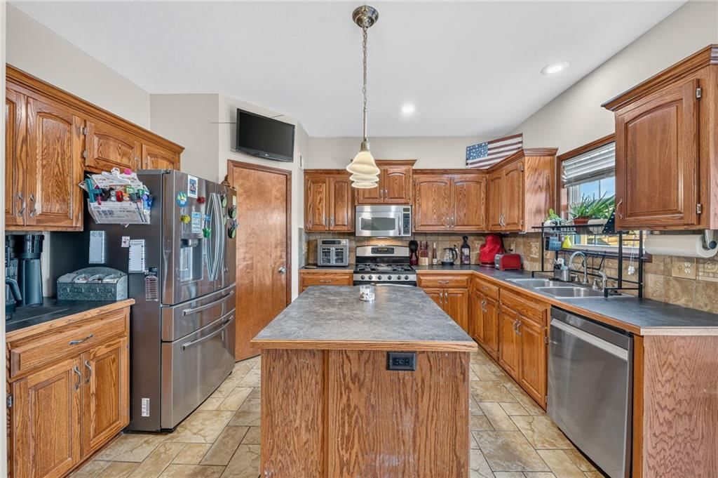 Open floor plan, kitchen island and kitchen backsplash at 2510 N 111th Terrace, Kansas City, KS 66109