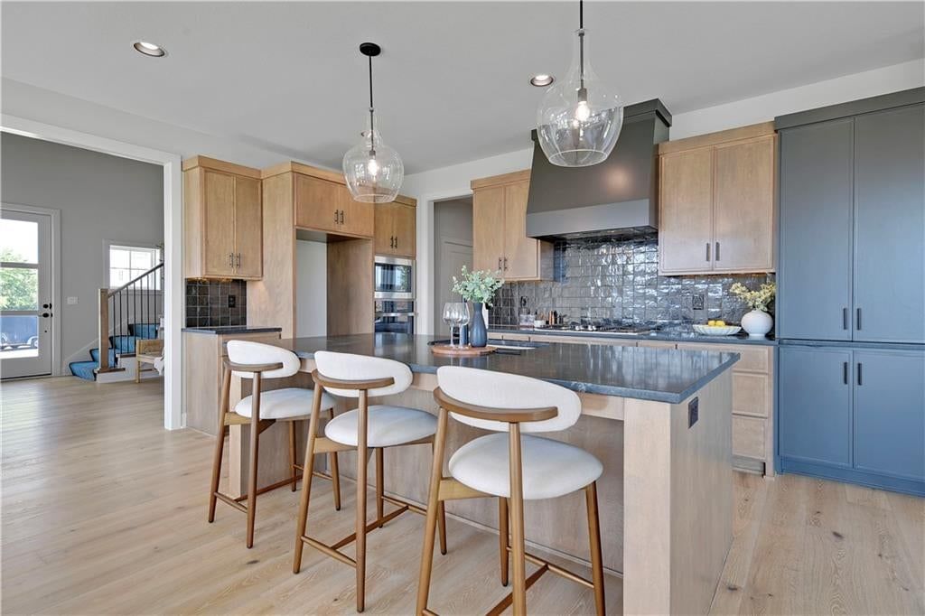 Kitchen island, statement lighting and gas range at 22097 W 99th Terrace, Lenexa, KS 66220
