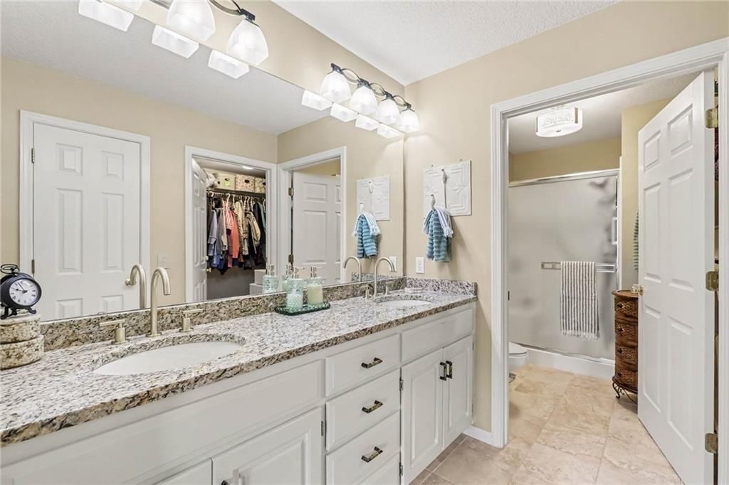 Tiled shower, double vanity and white vanity at 3213 Devonshire Drive, Platte City, MO 64079