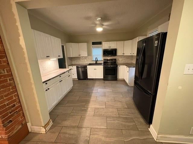 White kitchen, tile floors and kitchen backsplash at 312 N 17th Street, Kansas City, KS 66102