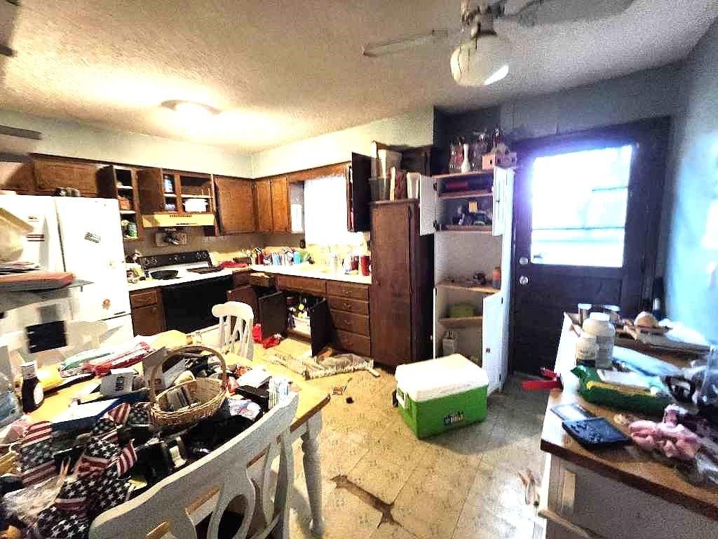 Wood kitchen cabinets and white appliances at 4934 Dixie Avenue, Kansas City, KS 66106