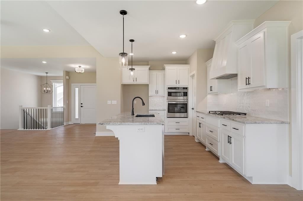 Kitchen island, white kitchen and granite counters at 12940 Sewell Avenue, Kansas City, KS 66111