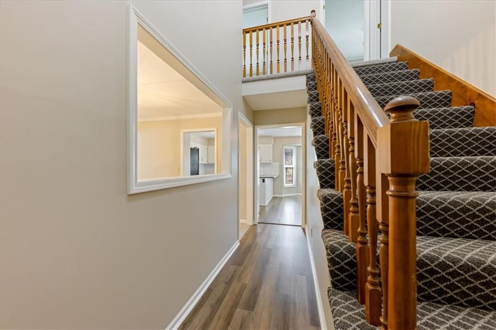 Luxury vinyl floors, staircase and wood stair railing at 12490 S Ortega Drive, Olathe, KS 66062