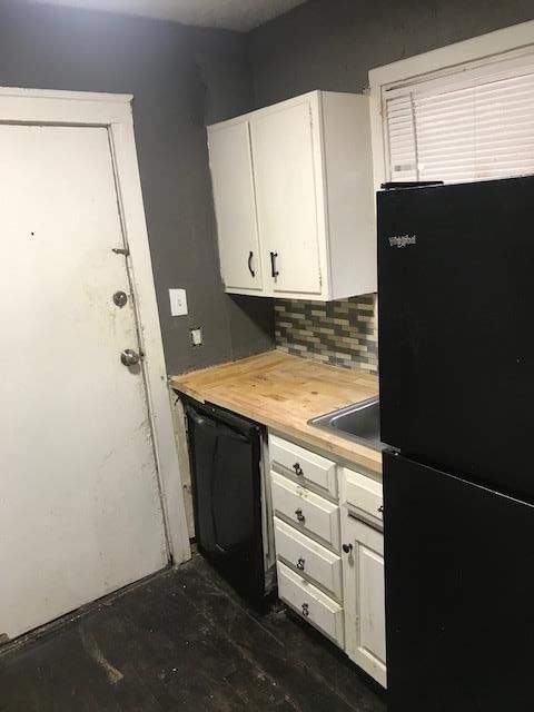White kitchen cabinets, butcher block countertops and kitchen backsplash at 5700 Brooklyn Avenue, Kansas City, MO 64130