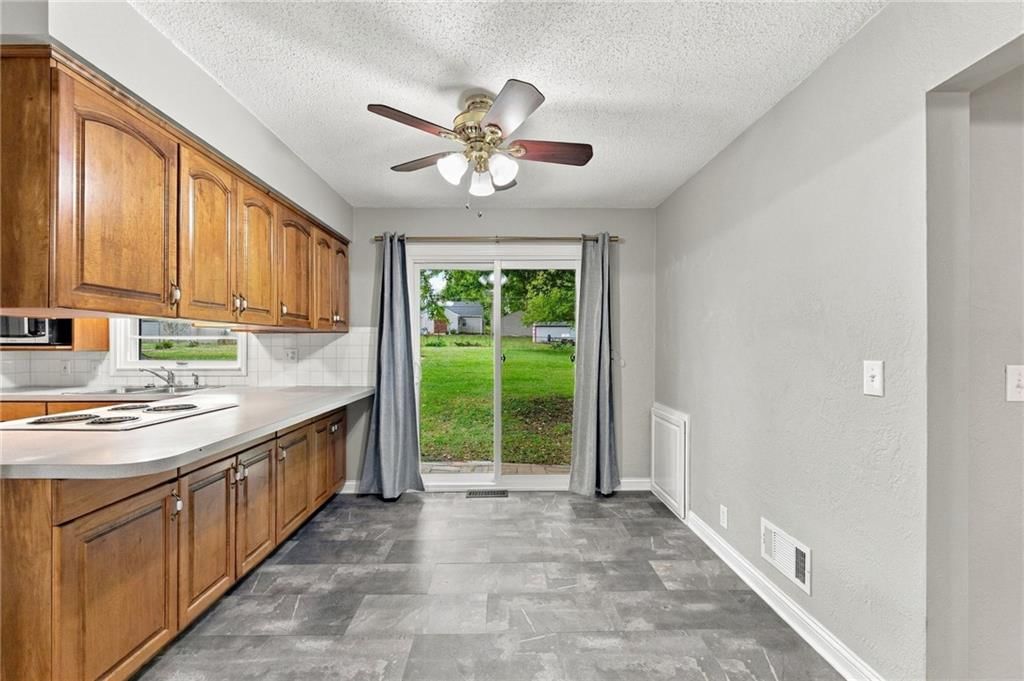 Breakfast nook, wood kitchen cabinets and kitchen backsplash at 10601 E Sheley Road, Independence, MO 64052