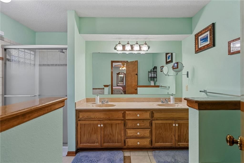 Tiled shower and double vanity at 811 N Mesa Street, Olathe, KS 66061