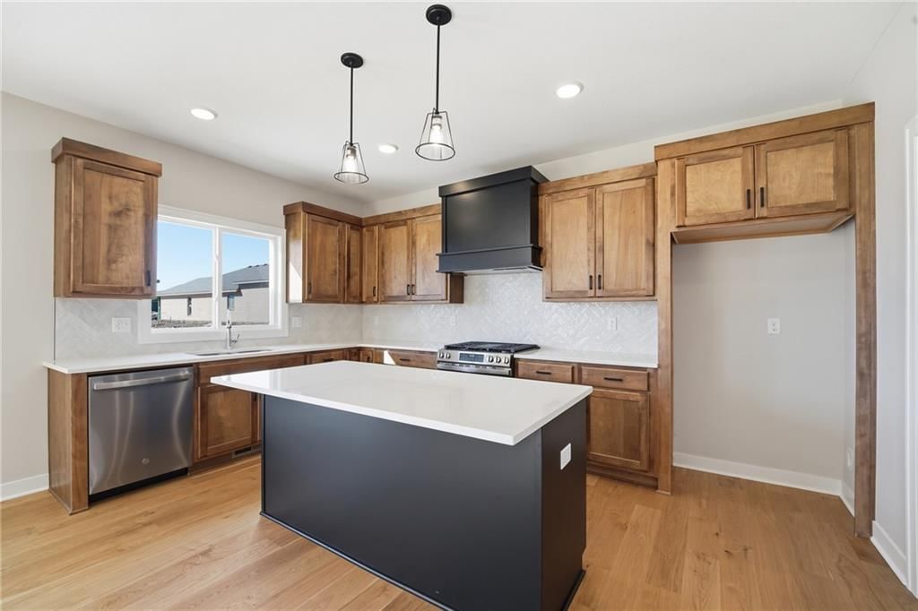 Kitchen island, hardwood floors and quartz counters at 18425 W 195th Street, Spring Hill, KS 66083