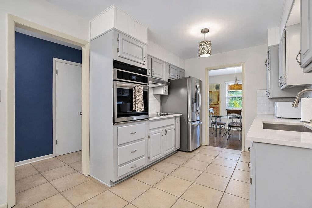 Gray kitchen cabinets, double oven and stainless steel appliances at 3109 W 79th Terrace, Prairie Village, KS 66208