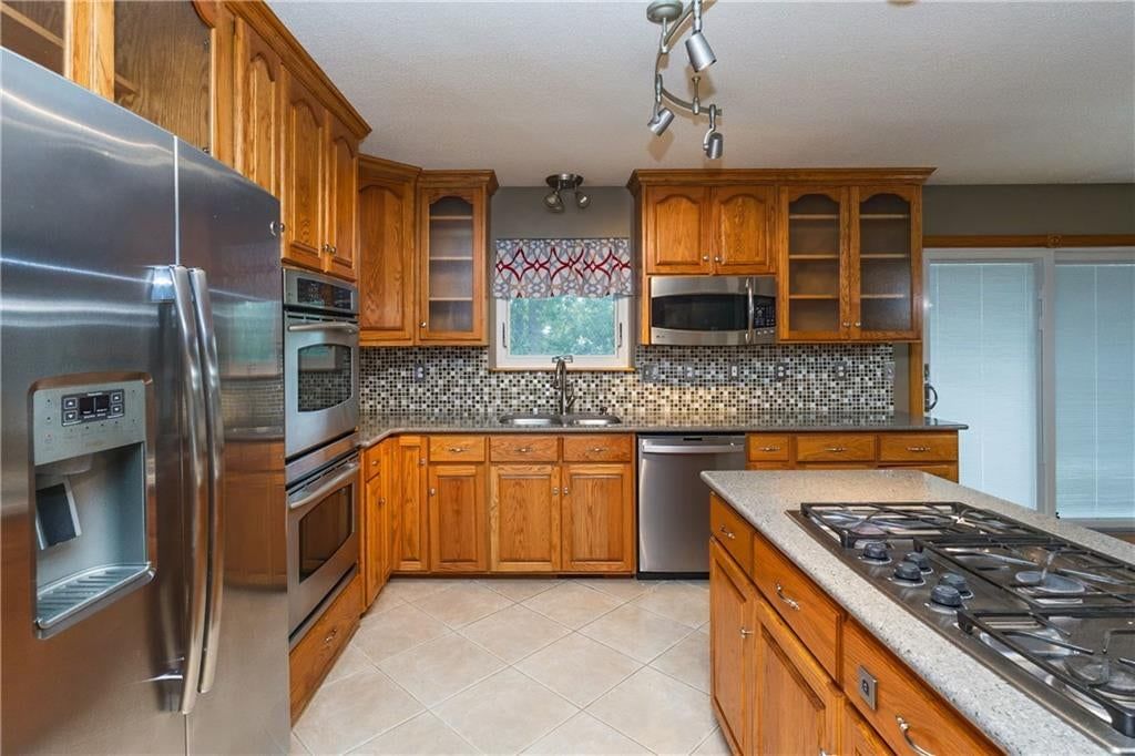 Kitchen island, gas range and tile floors at 140 Debra Street, Lansing, KS 66043