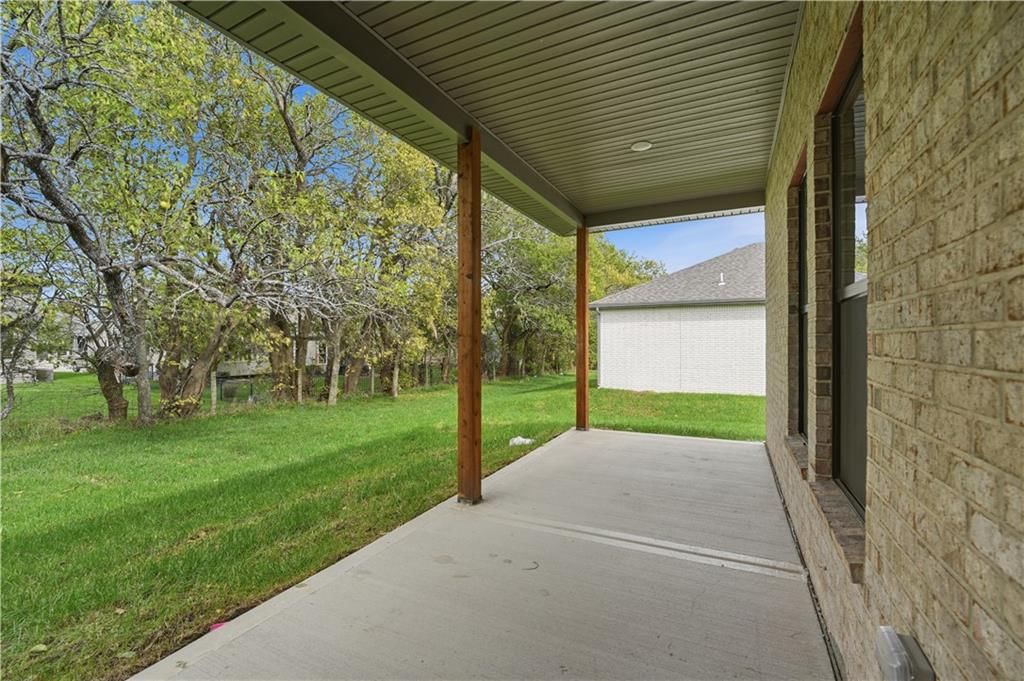 Mature trees, covered patio and concrete patio at 18420 W 195th Street, Spring Hill, KS 66083