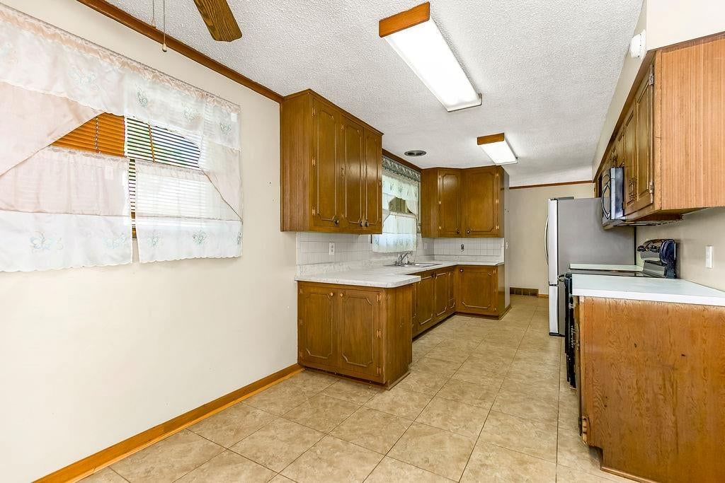Tile floors, wood kitchen cabinets and kitchen backsplash at 11801 E 45TH Terrace, Kansas City, MO 64133
