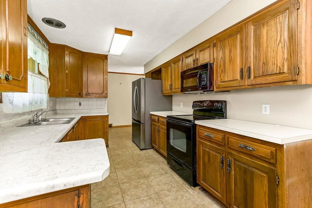 Electric range and black appliances at 11801 E 45TH Terrace, Kansas City, MO 64133