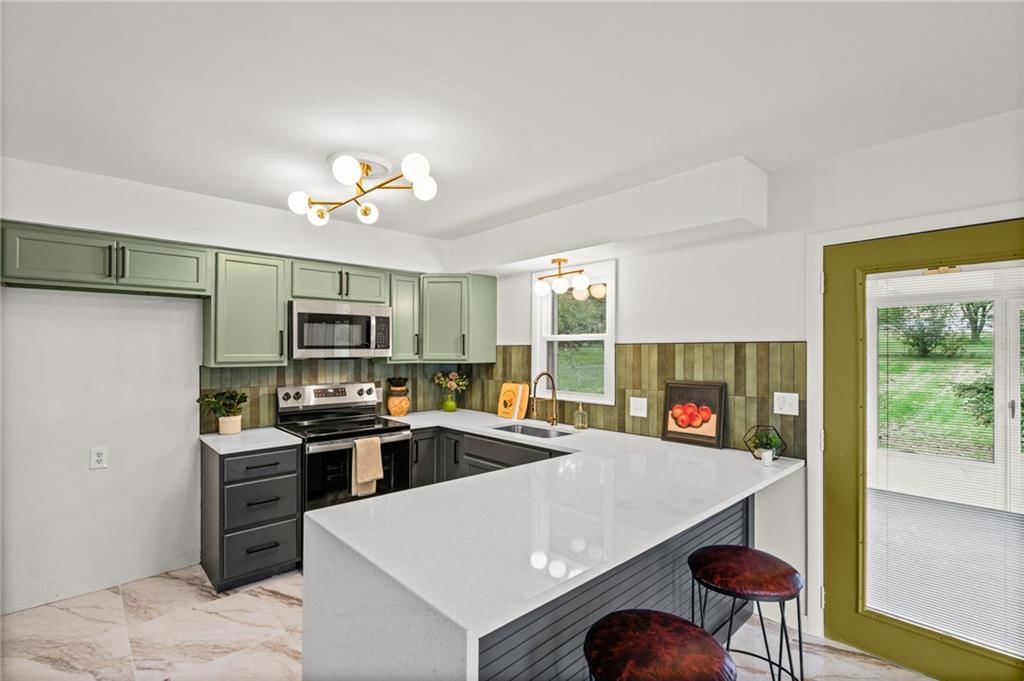 Updated kitchen, kitchen backsplash and white countertops at 7312 Hedges Avenue, Raytown, MO 64133