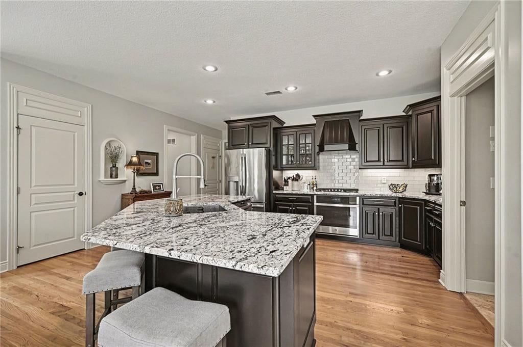 Kitchen island, granite counters and gas range at 10139 N Montgall Avenue, Kansas City, MO 64155