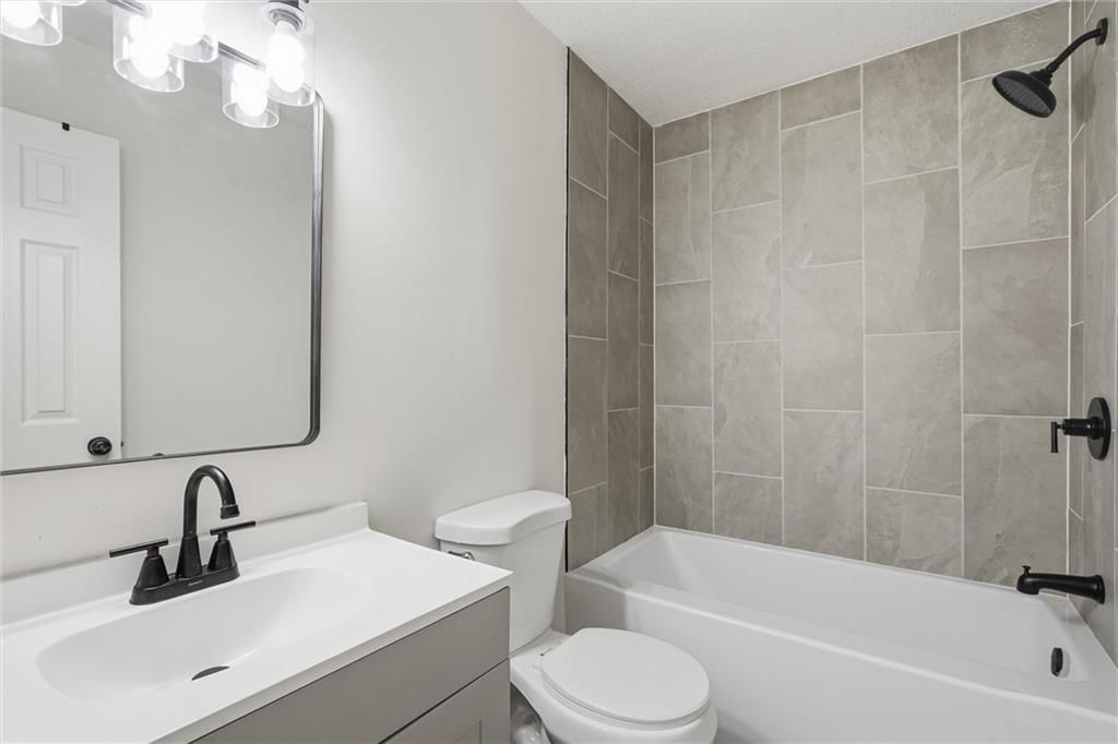 Tiled shower, white vanity and tub and shower combo at 307B E Main Street, Smithville, MO 64089