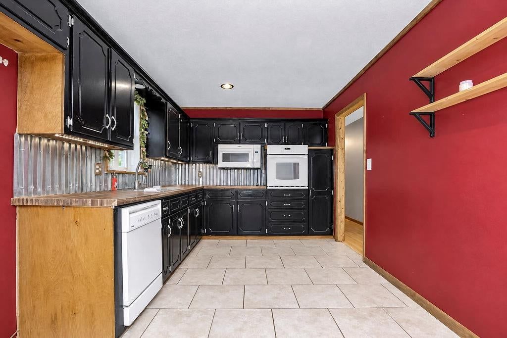 Butcher block countertops, tile floors and black kitchen cabinets at 11712 E 62nd Terrace, Kansas City, MO 64133