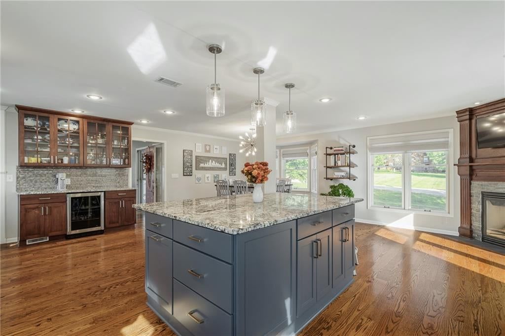Open floor plan, kitchen island and hardwood floors at 9260 Oakcrest Drive, Lenexa, KS 66227
