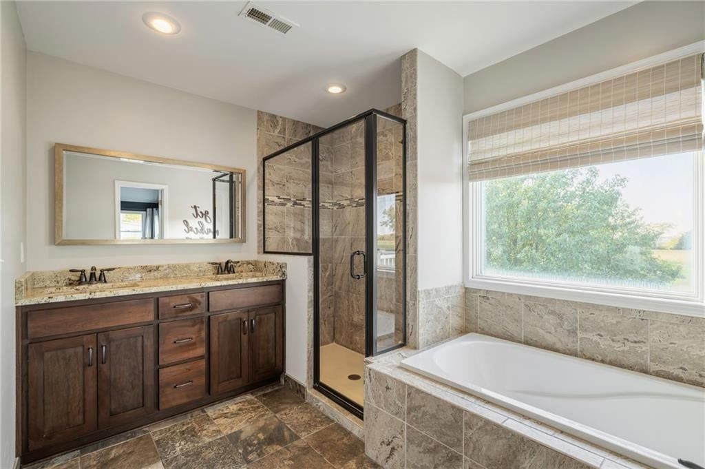 Walk-in shower, tiled shower and double vanity at 9260 Oakcrest Drive, Lenexa, KS 66227