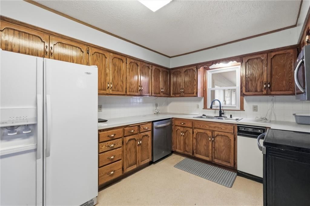 Second kitchen, wood kitchen cabinets and mixed-finish appliances at 24 Fairview Avenue, Liberty, MO 64068