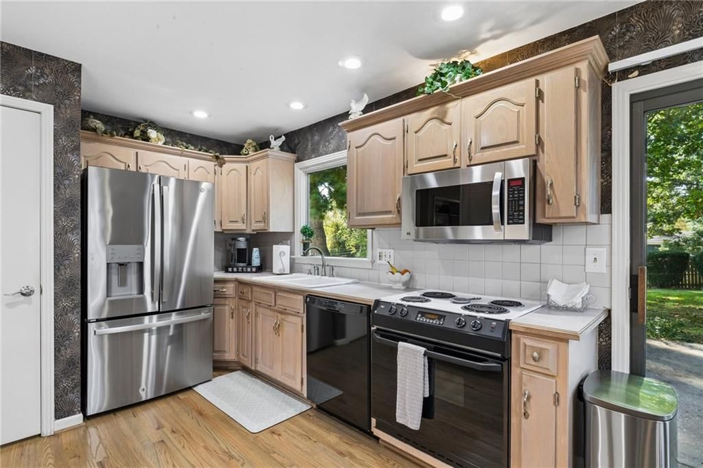 Stainless steel appliances, wood kitchen cabinets and electric range at 1513 NE Englewood Road, Kansas City, MO 64118